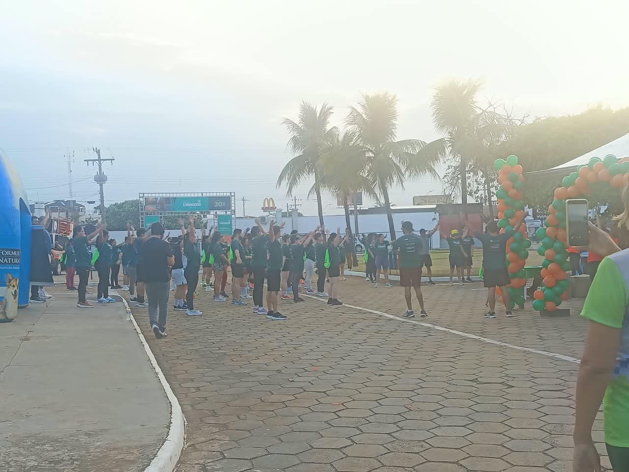 Grupo se alongando ao nascer do sol na Caminhada Unimed